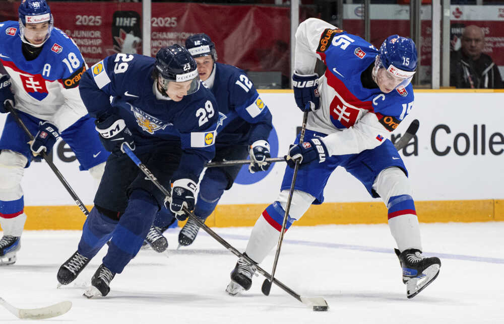 Arttu Alasiurua (uprostred) korčuľuje s pukom pred Slovákom Daliborom Dvorským (vpravo).