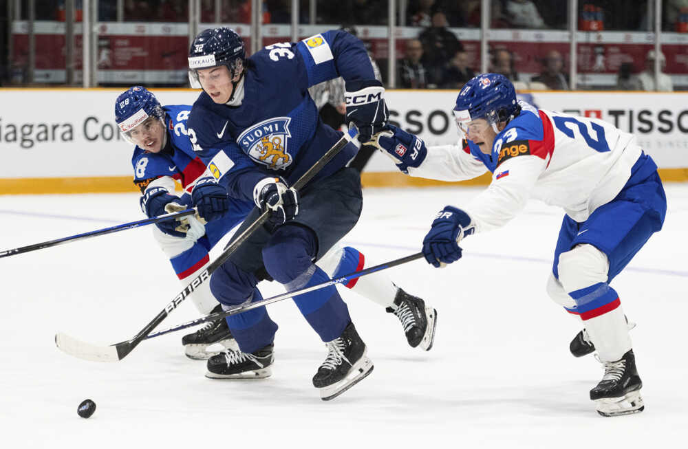 Emil Hemming (uprostred) korčuľuje s pukom pred Slovákmi Tomášom Kráľovičom (28) a Samuelom Barčíkom (23).