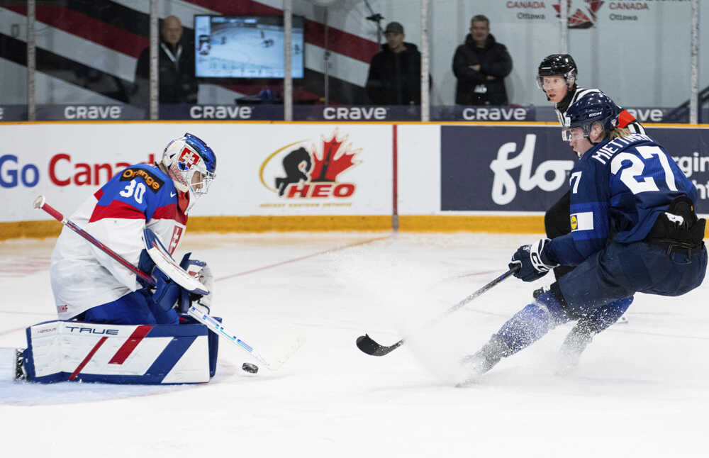 Julius Miettinen (vpravo) strieľa cez slovenského brankára Samuela Urbana (30).