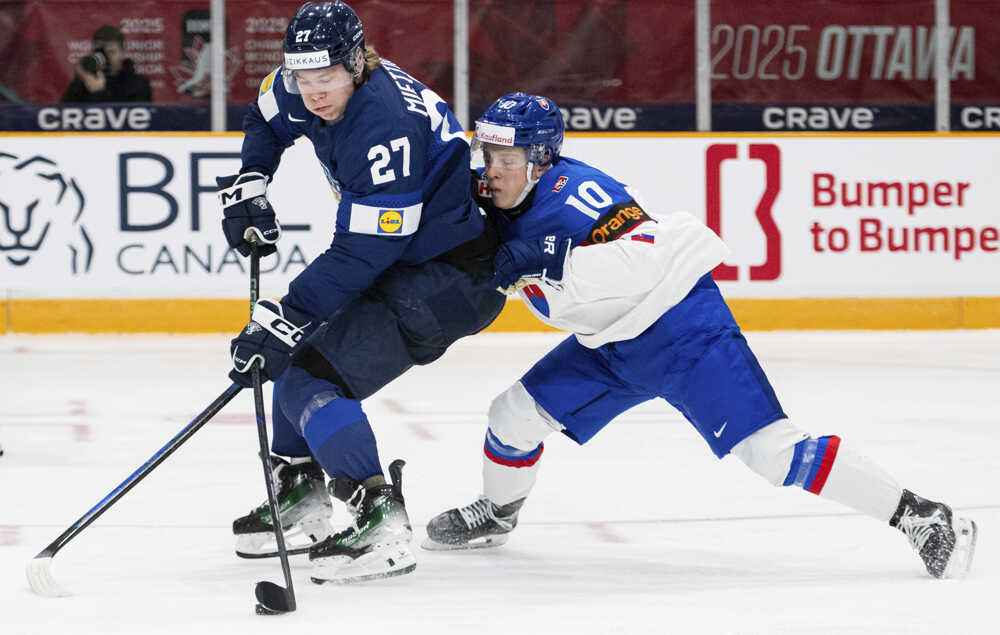 Julius Miettinen (vľavo) bojuje o puk so Slovákom Tomášom Pobežalom.