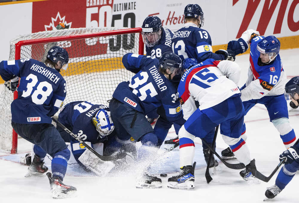 Arttu Tuhkala (uprostred vľavo) bojuje o puk so Slovákom Daliborom Dvorským (15) pred brankárom Petterim Rimpinenom.