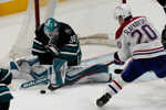 Juraj Slafkovský (20) a brankár San Jose Sharks Jaroslav Askarov.
