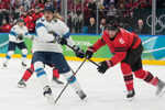 Kanaďan Travis Sanheim a Fín Roope Hintz v súboji na ZOH 2026.