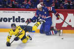 Švédsky hráč Marcus Johansson (vľavo) padá na ľad v súboji s Američanom Tageom Thompsonom.