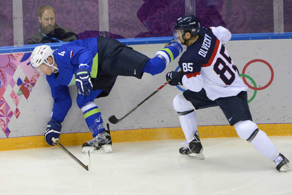 Slovenský hokejista Peter Ölvecký a hráč Slovinska Andrej Tavzelj v súboji.