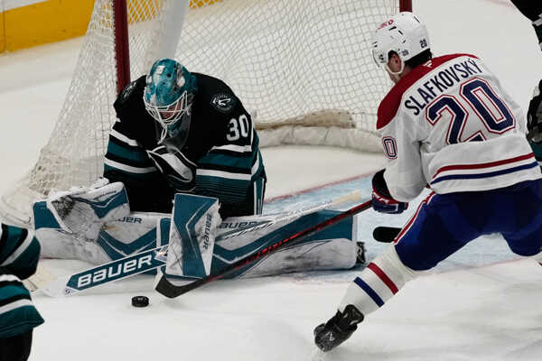 Juraj Slafkovský (20) a brankár San Jose Sharks Jaroslav Askarov.