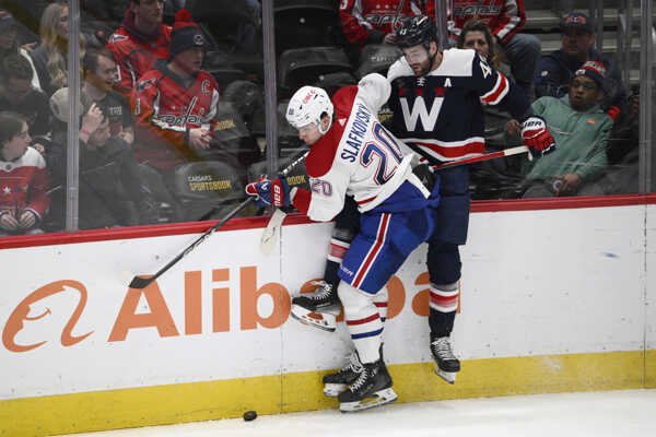 Slafkovský súperí o puk s Wilsonom.