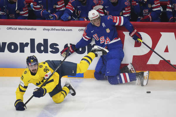 Švédsky hráč Marcus Johansson (vľavo) padá na ľad v súboji s Američanom Tageom Thompsonom.