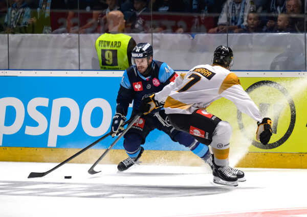 Zachary Osburn z Nitry a Frans Haara z tímu Skelleftea v súboji o puk.